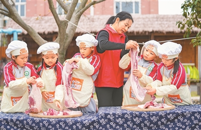 12月4日，浙江省湖州市長興縣泗安鎮(zhèn)二界嶺中心幼兒園開展“迎大雪 藏美味”主題活動，孩子們在泗安鎮(zhèn)云峰村志愿者的指導(dǎo)下體驗(yàn)腌制臘肉，了解大雪節(jié)氣的傳統(tǒng)習(xí)俗，感受濃濃的節(jié)氣文化。陳海偉攝（人民視覺）