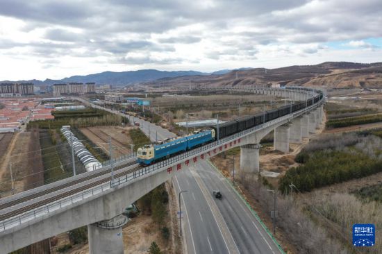 11月21日，在內(nèi)蒙古赤峰市克什克騰旗，一列由電力機(jī)車牽引的貨運(yùn)列車行駛在內(nèi)蒙古集通鐵路經(jīng)棚特大橋上（無人機(jī)照片）。新華社記者 貝赫 攝