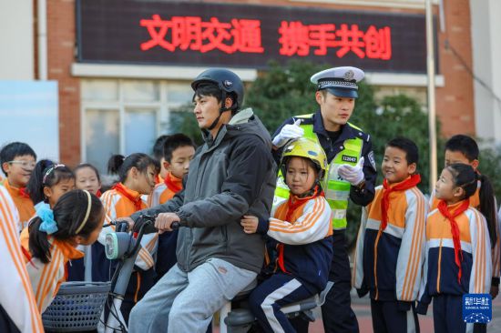 12月2日，在山東省青島汾陽(yáng)路小學(xué)，青島交警李滄大隊(duì)民警向?qū)W生講解如何安全騎乘電動(dòng)摩托車。新華社發(fā)（張鷹攝）